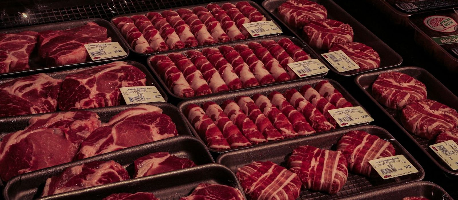 Bandejas com cortes de carne no balcão refrigerado